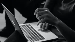 Close-up of a hand typing on a laptop keyboard, highlighting technology use and focus in a modern workspace setting.