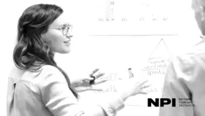 Woman explaining concepts on a whiteboard during a brainstorming session, showcasing collaboration and creativity.