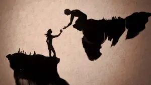 Silhouette of two figures, one reaching out to help the other across a chasm, symbolizing support and connection.