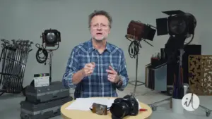 Instructor demonstrating filmmaking techniques with cameras and lighting setup in a studio environment.