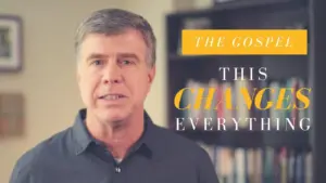 Man speaking about the gospel, with bold text emphasizing "This Changes Everything" and a bookshelf in the background.