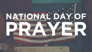 American flag backdrop with bold text announcing National Day of Prayer celebration.