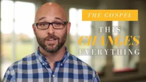 Man in glasses and plaid shirt speaks about the transformative power of the gospel in a well-lit, inviting setting.