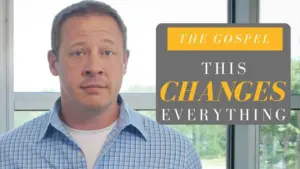 Man in a blue checked shirt standing by a window with a graphic highlighting "The Gospel Changes Everything."