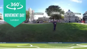 A panoramic view of London featuring Movement Day signage and vibrant city surroundings with green grass.