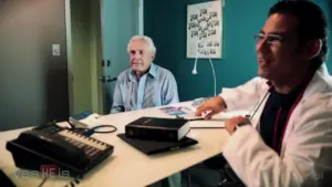 Doctor consulting with elderly patient in a modern office setting, featuring medical tools and a friendly atmosphere.