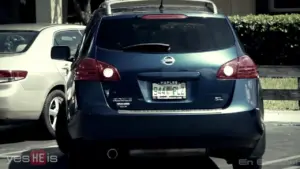 Blue Nissan SUV parked in a lot, showing rear view and distinctive license plate.