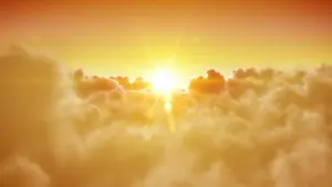 Golden sunrise over fluffy clouds, creating a serene and uplifting morning atmosphere in the sky.