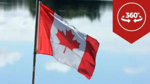 Canadian flag waving against a scenic backdrop, featuring a vibrant red and white design with a maple leaf. 360-degree view.