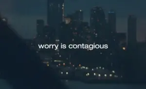 City skyline at night with the text "worry is contagious" displayed prominently.