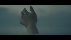 A close-up of a hand reaching upward against a cloudy sky, symbolizing hope and aspiration.