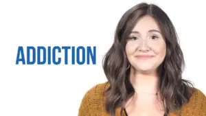 Smiling woman with shoulder-length hair beside the word "ADDICTION" in bold blue letters, highlighting a positive message.