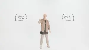 Person gesturing with a thumbs-up in a light studio, surrounded by speech bubbles labeled "XYZ" on either side.