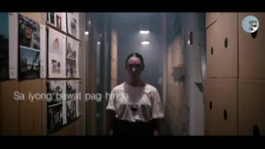 Young woman standing in a corridor filled with artwork, surrounded by soft lighting and ambient haze.