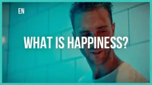 Smiling man in a bright setting pondering the question, "What is happiness?" against a colorful background.