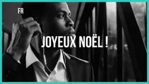 Black and white image of a man in a suit with earbuds, celebrating with the text "Joyeux Noël!" in bold letters.