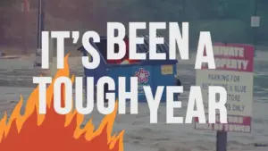 Image of a flooded area with a trash bin, featuring bold text overlay saying "It's been a tough year" and fire graphic.