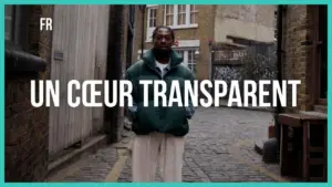 Person standing in a narrow street, wearing a green jacket, with the text "UN CŒUR TRANSPARENT" prominently displayed.