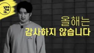 Young man looking down with text in Korean, conveying a message of not expressing gratitude this year, in monochrome style.