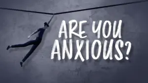 Person balancing on a thin line against a textured wall, with bold text asking, "Are you anxious?" conveying uncertainty.