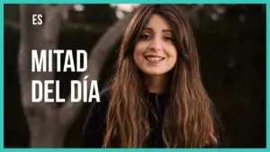 Young woman smiling outdoors with long hair, text overlay "MITAD DEL DÍA" in a vibrant design.