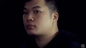 Close-up of a focused young man looking thoughtfully to the side against a dark background. Ideal for exploring emotions.