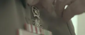 Close-up of military medals being adjusted on a uniform, highlighting symbols of honor and achievement.