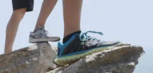 Two pairs of running shoes on rocky terrain, highlighting outdoor fitness and adventure in a natural setting.