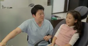 Pediatric dentist interacting with a cheerful young girl in a modern dental clinic. Bright and inviting atmosphere.