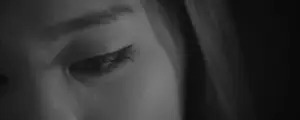 Close-up of a woman's eye, capturing emotion with soft focus and dramatic lighting in black and white.