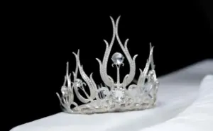 Elegant silver crown with intricate design and sparkling gems, set against a dark background. Perfect for pageantry.