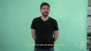 Man in a black shirt stands against a green backdrop, expressing thoughts on personal experiences.