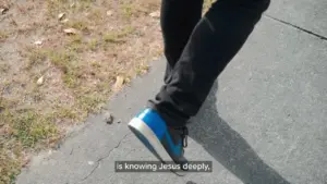 Person wearing blue sneakers walking on a pavement, emphasizing comfort and casual style.