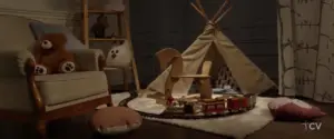 Cozy children's playroom featuring a teepee, plush toys, and a train set on a soft rug, creating a warm atmosphere.