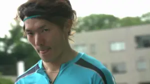 Athlete in a turquoise jersey with a headband, displaying a playful expression against an outdoor backdrop.