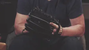 Person holding a black baseball glove, showcasing craftsmanship and readiness for the game.