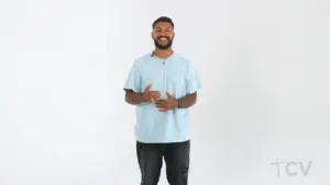 Smiling man in a light blue shirt stands confidently against a white background, showcasing a positive demeanor.