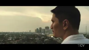 Man gazing thoughtfully over a city skyline at sunset, capturing a moment of reflection and urban beauty.