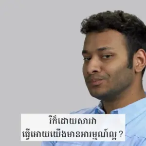 Man with a playful expression posing against a gray background, displaying a text bubble in a different language.