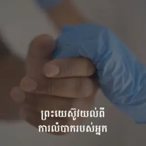 A close-up of a gloved hand holding another hand, symbolizing care and support in a healthcare setting.