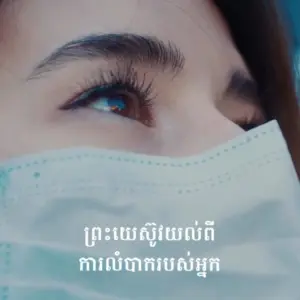 Close-up of a woman's eye above a medical mask, emphasizing health and safety in a supportive environment.