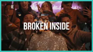 Group of friends at a lively party with the phrase "Broken Inside" overlaying the scene, capturing a mix of joy and introspection.