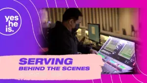 A sound engineer works on mixing equipment in a vibrant studio setting, showcasing a behind-the-scenes moment.