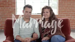 Couple sitting close together on a couch, emphasizing the theme of marriage with a soft, hand-written font overlay.