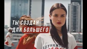 Stylish young woman in a cityscape, promoting a bold, empowering message in Russian about achieving more.