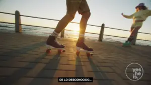 Person skating on roller skates at sunset along a boardwalk, with playful vibes and scenic ocean background.