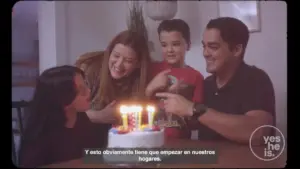 Happy family celebrating a birthday with a cake and candles, capturing joyful moments together at home.