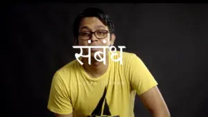 Young man in a yellow shirt with glasses, seated against a dark background, features the word "संबंध" prominently.