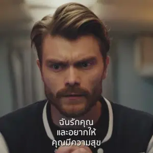 A focused man with a mustache and stylish hair, expressing deep emotions in a dramatic scene. Text in Thai below him.