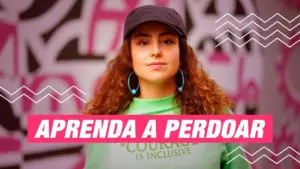 Woman in a cap wearing a green shirt with the phrase "Aprenda a Perdoar" against a vibrant background.